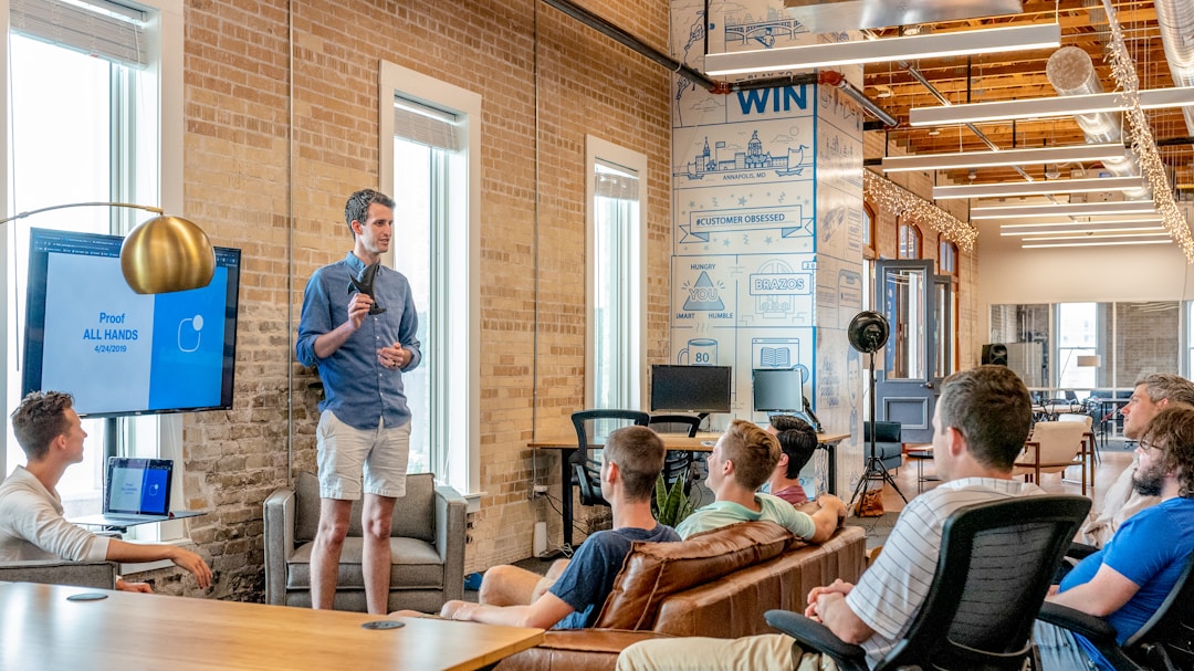 The Benefits and Challenges of Integrating AI Into Business Operations 2 A group of people seated in a room, attentively listening to a man presenting on AI implementation in business.