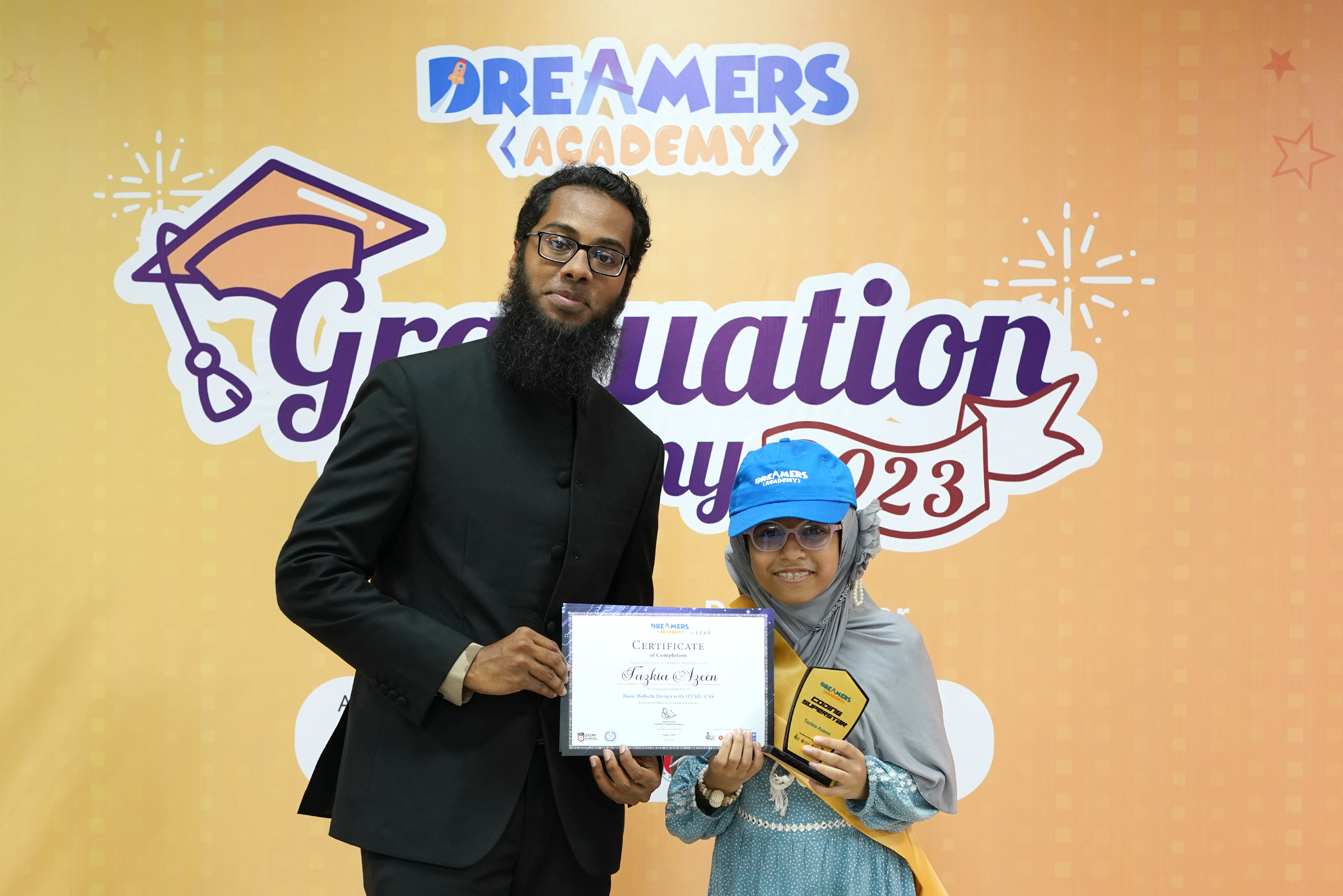 Dreamers Academy founder Sharif Ahmed handing certificate and crest to a student at its graduation ceremony
